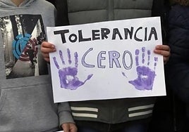 A person holds banner with a zero-tolerance slogan.