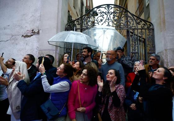 Spectators sheltered from the rain when one brotherhood in Malaga city was caught by a shower.