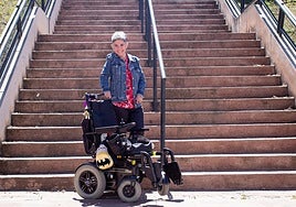 Ana Raya with her wheelchair in front of some stairs in a park in Granada.
