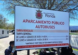 Workers putting up the information sign in the car park next to the fairground.