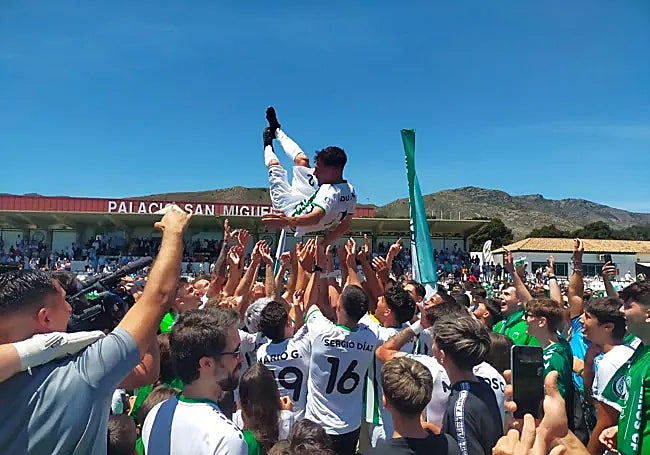 Fans and players celebrate together on the pitch.