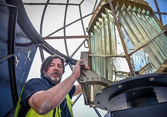 Jorge Lacuesta, a technician with Spain's navigation aid service, poses with the lighthouse lantern.