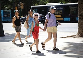 Tourists walking along the Paseo del Parque in Malaga.