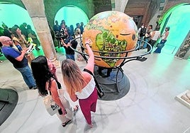 Vistors gather around a globe in the Discovery room.