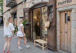 Two tourists, next to the entrance of a tourist apartment in the centre of Barcelona.