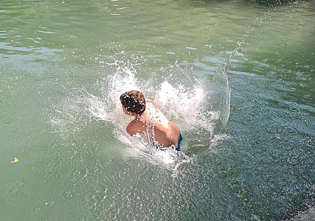 A young boy jumps into the water at El Puente.