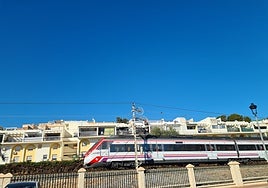 A Cercanías train passes the Parque de la Batería, in Torremolinos.