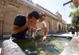 Tourists cool off from the sweltering heat at a fountain in the Mezquita de Córdoba.