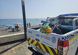 A Local Police vehicle, with items removed from the beachfront.