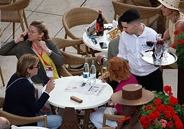 Waiter serving customers in a restaurant in the centre of Malaga.