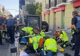 Emergency services attend to one of the passers-by hit by the police car.