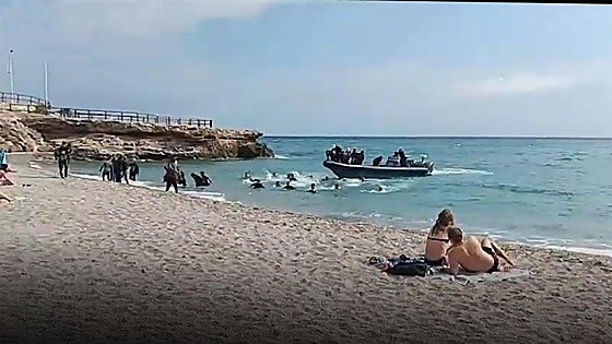 This is the moment a boat dropped around 40 migrants on a busy Costa del Sol beach, before speeding off