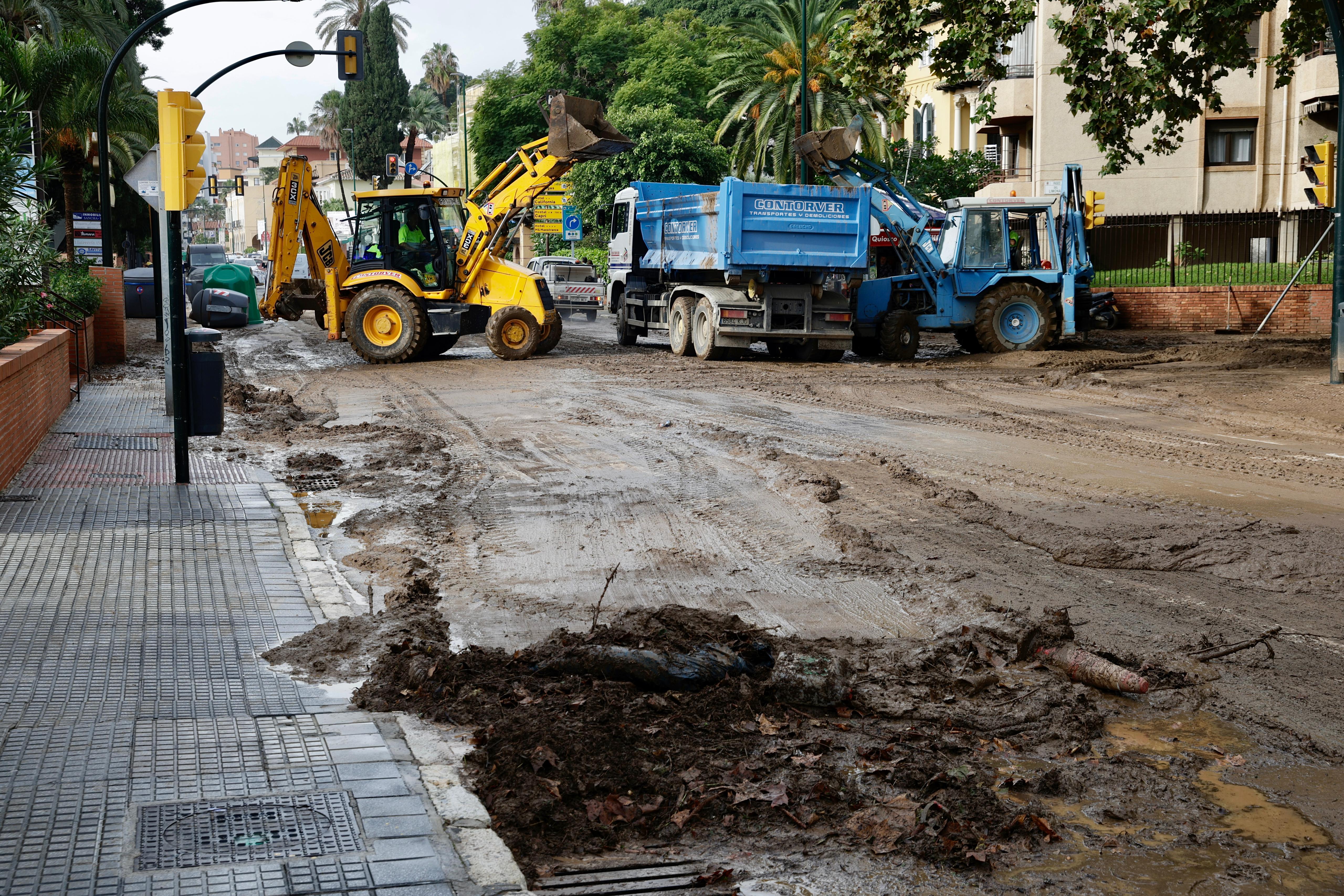 Operarios trabajan en la limpieza del paseo de Sancha y zona de El Limonar, donde quedan aún acumulados de barro y balsas de agua.