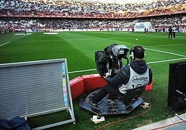 A television cameraman at a football match.
