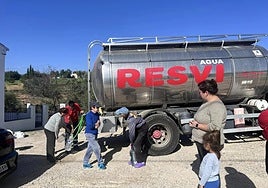 Residents in Comares fill bottles from water trucks.