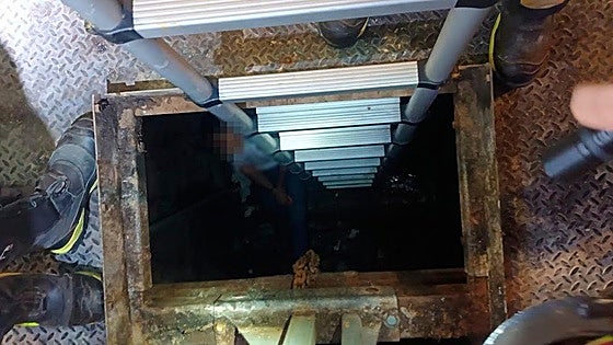 Trapped young man clutching rosary beads in his hands rescued from underground rubbish container in Malaga