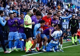 The Malaga bench celebrate with Dioni after his header led to side's opener.