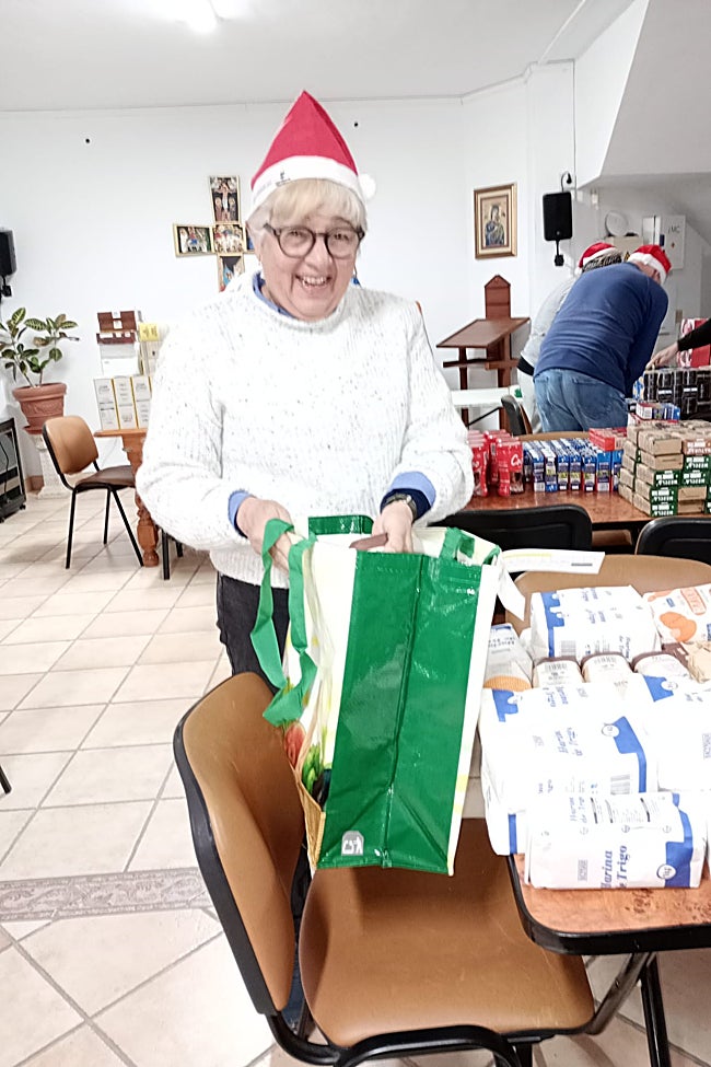 Lux Mundi director Gloria Uribe packs food bags for local families.