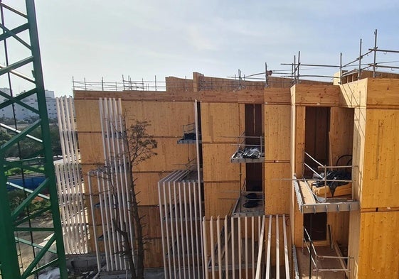 Workers assemble one of the wooden panels.