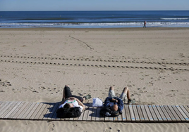 Two people lie in the sun on Malvarrosa beach in Valencia on Friday.