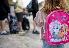 A young girl waits for a school bus in a file image.