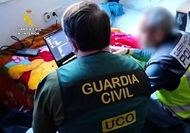 Officers analyse the contents of one of the seized computers.