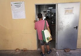 A person at the door of a soup kitchen.