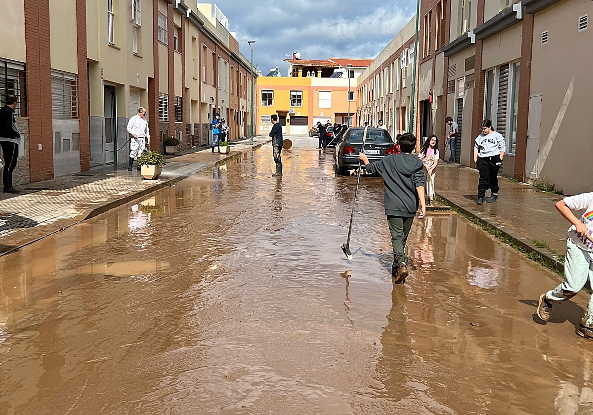 Residents of Campanillas clean the mud from their own streets.