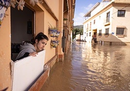 A resident looks out from her house onto the flooded street in the Doña Ana neighbourhood in Cártama.