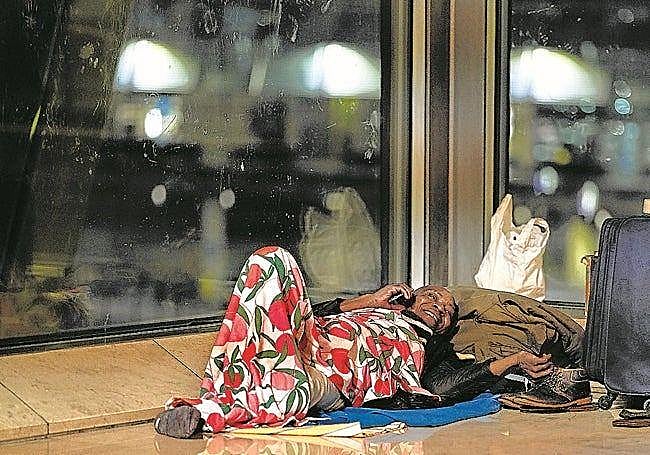 A man talks on the phone in one of the wings of Terminal 4, where the homeless gather to spend the night.