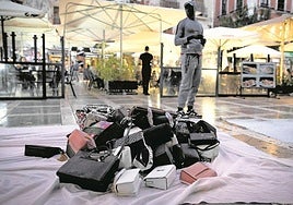 A 'mantero' or street vendor offers counterfeit goods in a central square in Granada.