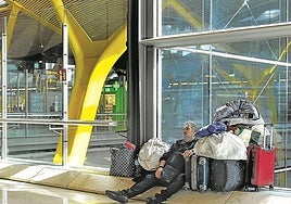 A homeless man rests next to his belongings in Terminal 4 of Barajas.