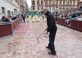 A worker sprays the anti-wax liquid before the procession of the Cofradía de la Pollinica.