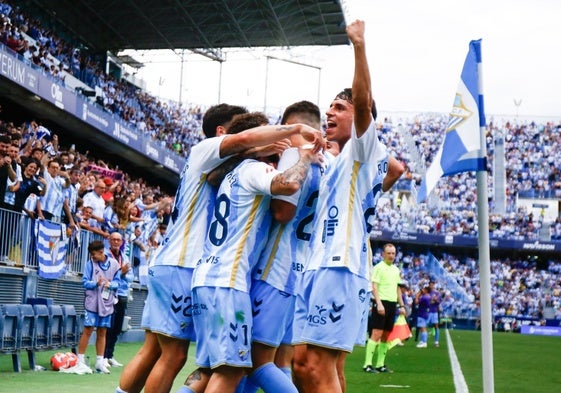 Malaga players celebrate Antoñito after scoring the penalty.