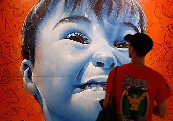 Lalone signs one of the 21 murals made specifically for the exhibition.