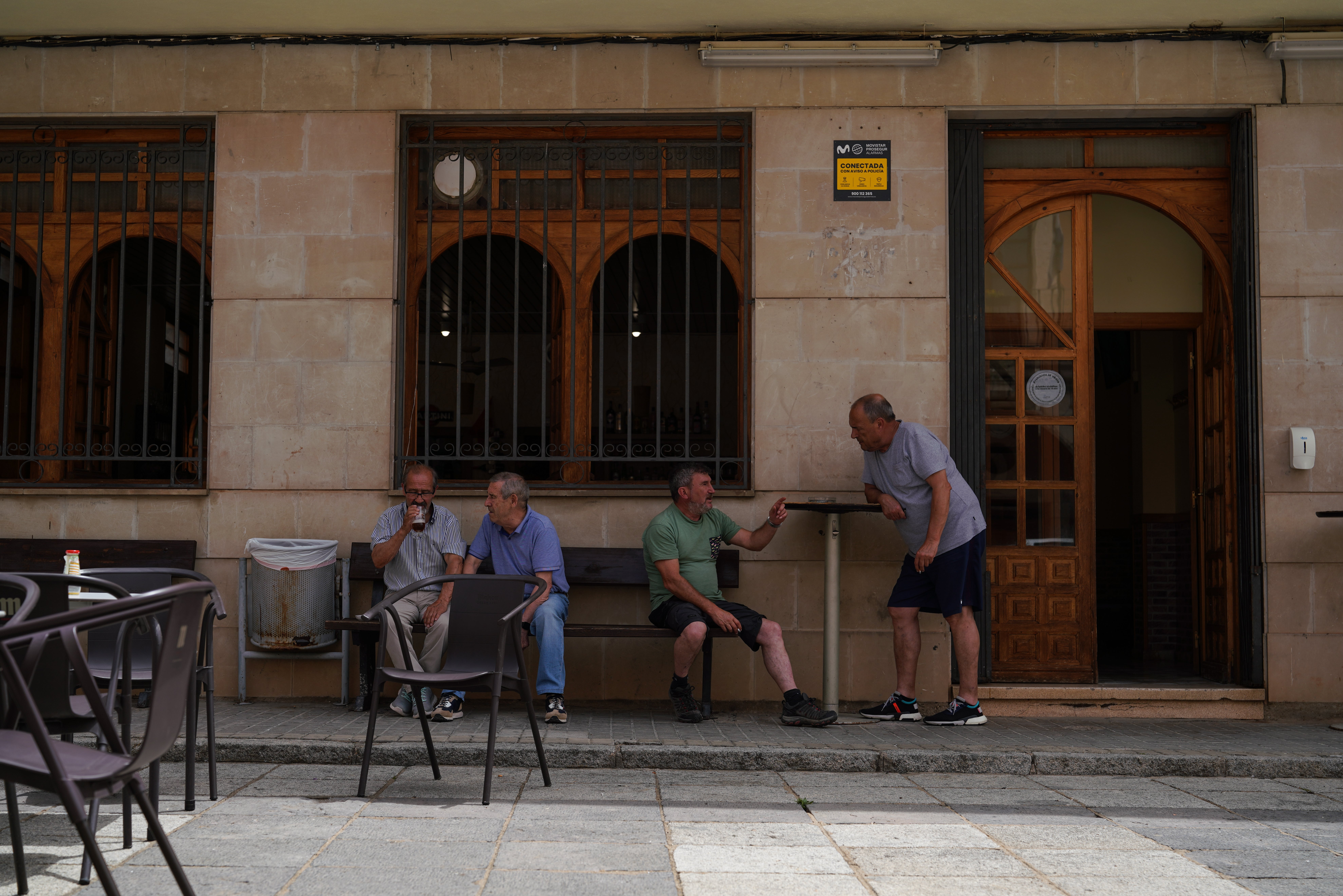 Residents of Bayubas chat outside the bar