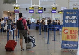 Tourist walks with his luggage to the Ryanair check-in desks.
