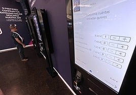 Spectator buying a ticket at interactive box office at the entrance to Vialia cinema.