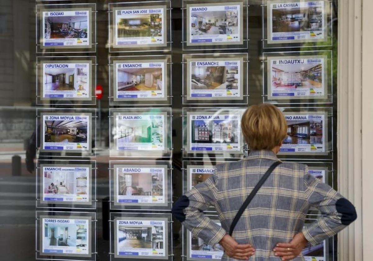 File image of a woman looking at advertisements in a real estate agency window.