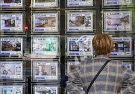 File image of a woman looking at advertisements in a real estate agency window.