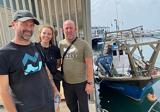 David León and Bárbara Conejero, from the Asociación Hombre y Territorio and fisherman Eduardo Peña, with the boat 'Jaime and Sara' in the background.