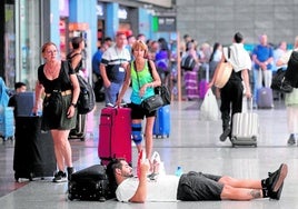 A passenger waits for his train lying on the floor at María Zambrano station in Malaga on Tuesday.