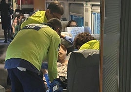 Emergency services attend to a female passenger inside the stationary train.