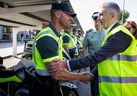 Minister of the interior Fernando Grande-Marlaska greets a Guardia Civil officer from the traffic operation.
