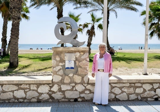 Councillor Teresa Porras standing next to the beach's quality label.