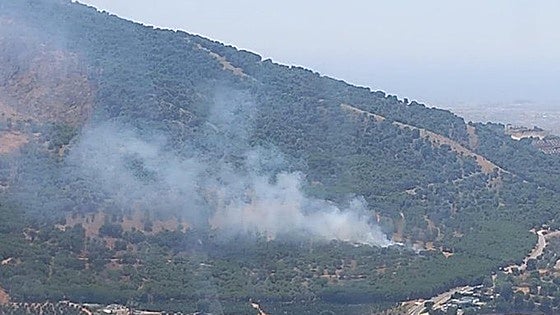 Firefighting aircraft and teams on the ground work to extinguish wildfire in Guadalhorce valley town