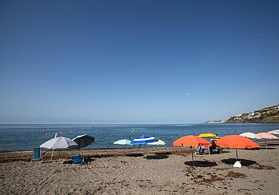 Parasols reserving a place on La Guardia beach in Salobreña, a practice expressly forbidden.
