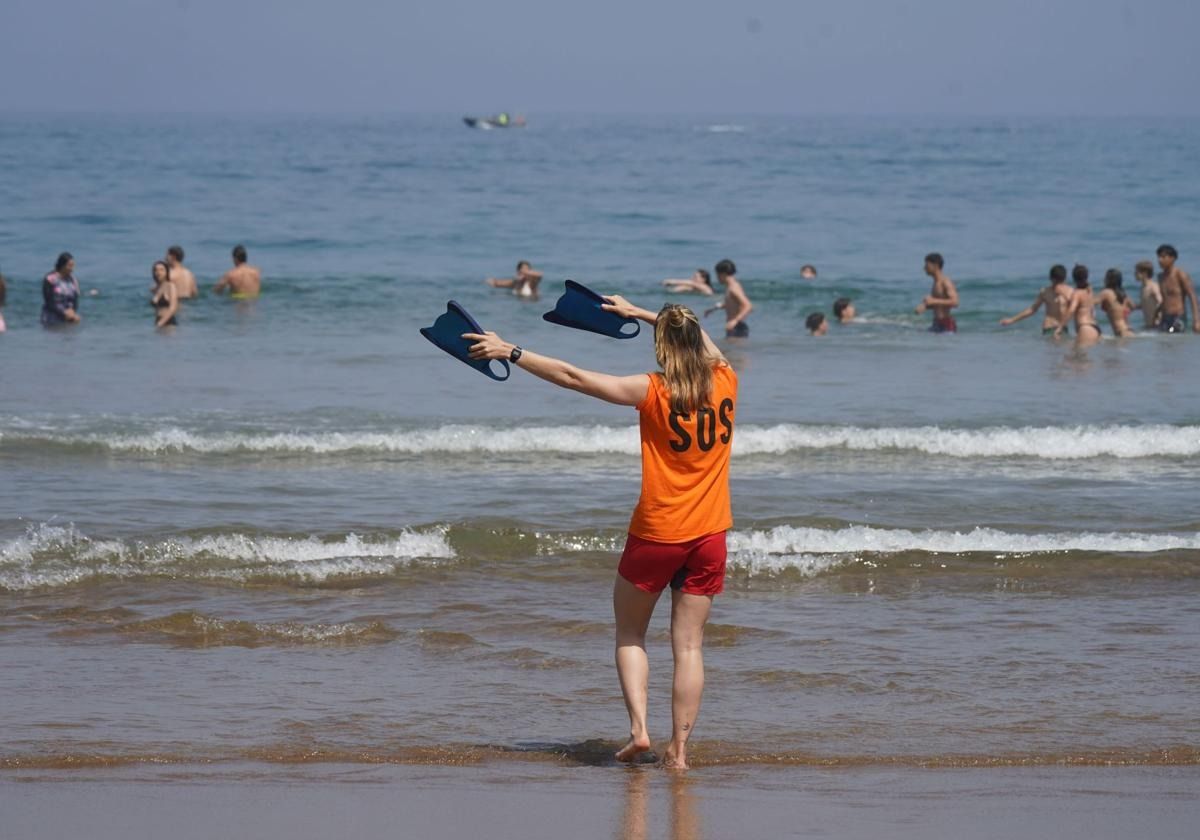 A lifeguard signals to a group of bathers on Arriatera beach.