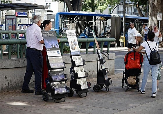 Two Jehovah's Witnesses try to engage with some passers-by in Malaga's main Alameda.
