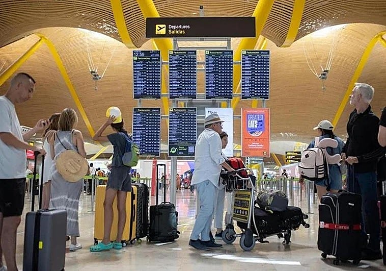 Passengers with suitcases at Madrid-Barajas Airport this summer.